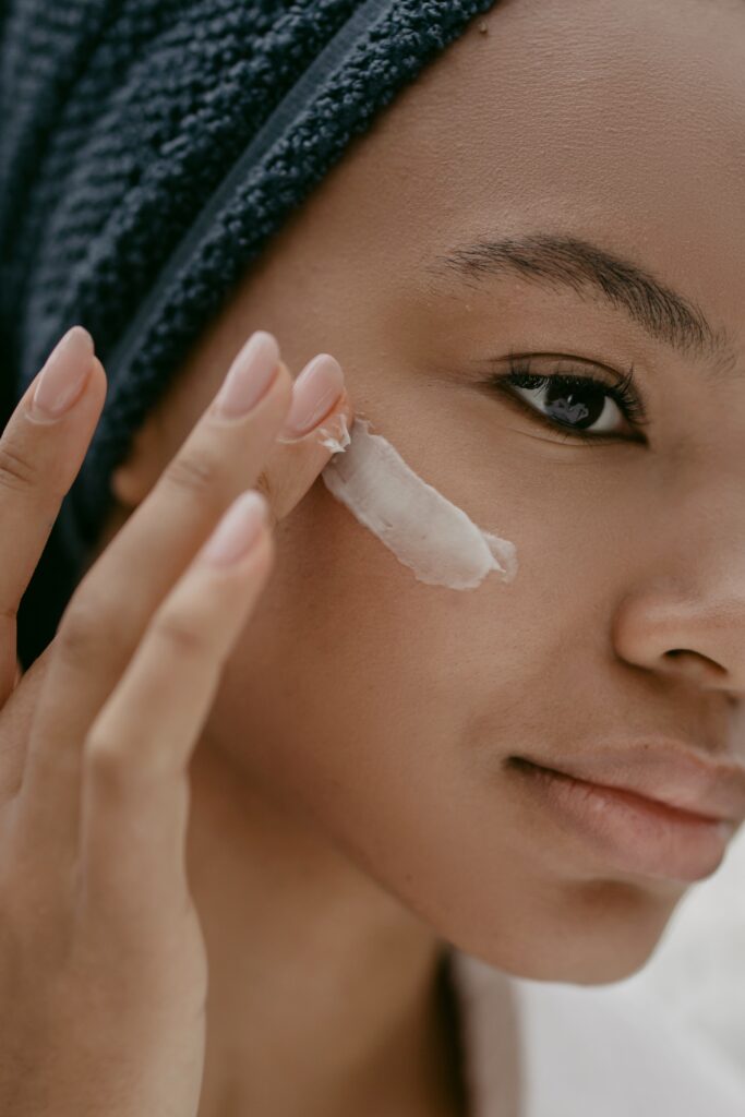 A woman nourishing her face with a cream for healthier skin.