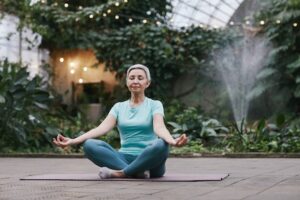 health goals: a woman meditating in a greenhouse.